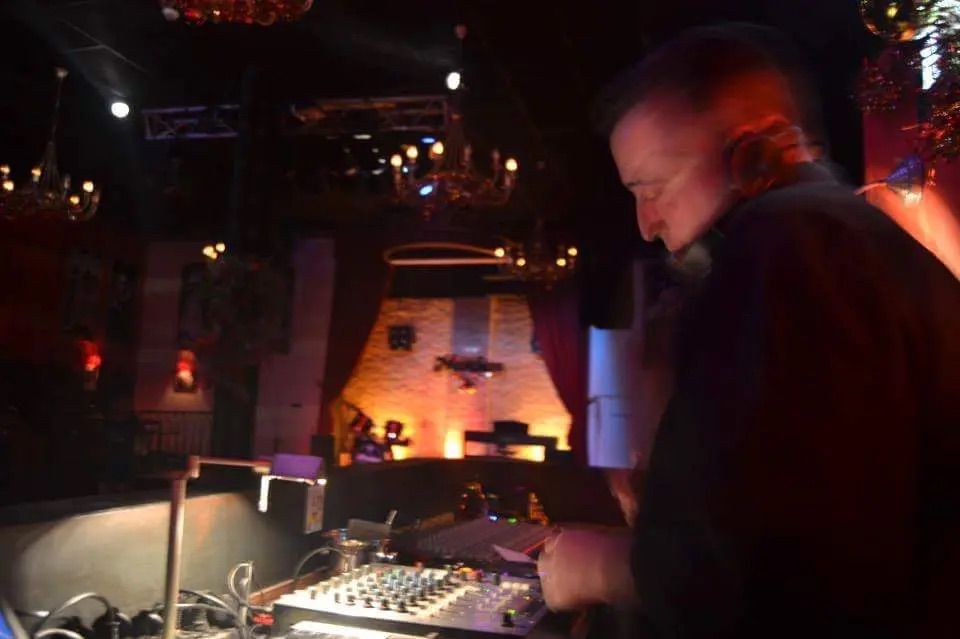 Djtofol mezclando música en una cabina con iluminación nocturna